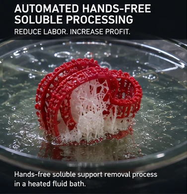 Hands-free soluble support removal process showing white support wax dissolving in a heated fluid bath. Hands-free soluble support removal process showing white support wax dissolving in a heated fluid bath.